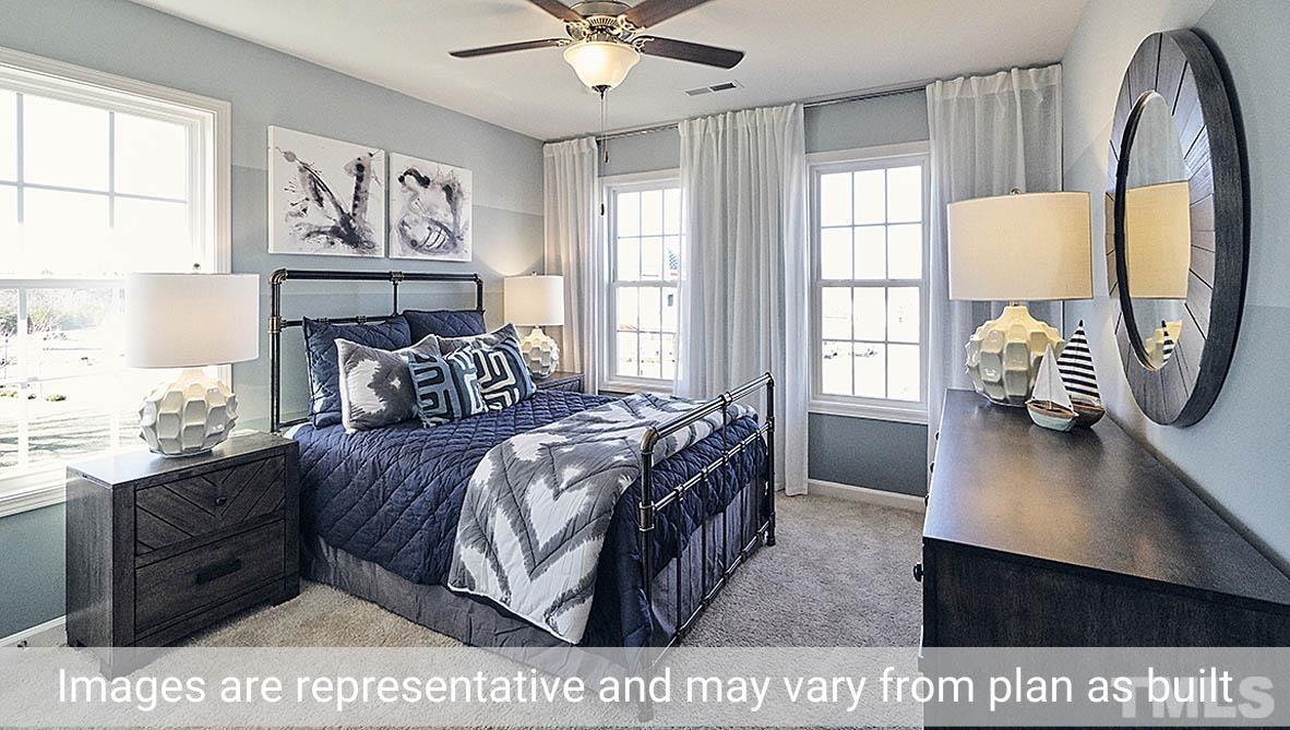 5037 Chase Hill Way Raleigh, NC 27603 - Photo 25 of 41 a bedroom with a bed a dresser next to a window