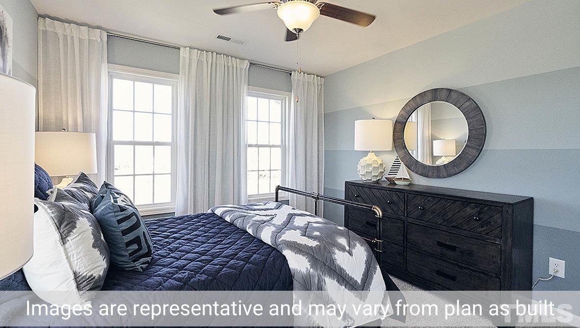 5037 Chase Hill Way Raleigh, NC 27603 - Photo 26 of 41 a bedroom with a bed a dresser and windows