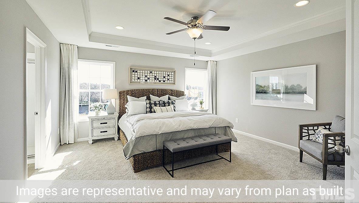 5037 Chase Hill Way Raleigh, NC 27603 - Photo 30 of 41 a bedroom with a bed a table and painting