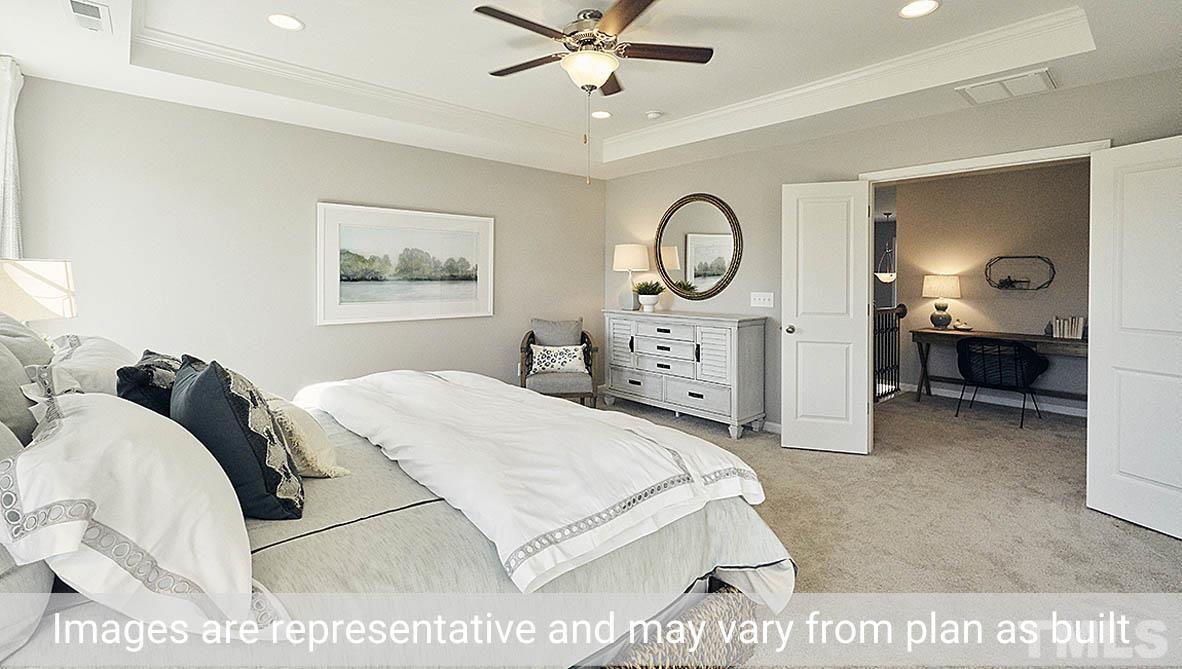 5037 Chase Hill Way Raleigh, NC 27603 - Photo 32 of 41 a bedroom with a bed and a chandelier