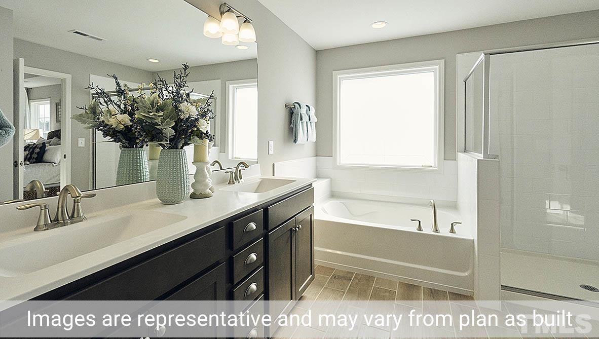 5037 Chase Hill Way Raleigh, NC 27603 - Photo 34 of 41 a bathroom with a sink a large mirror and a bathtub