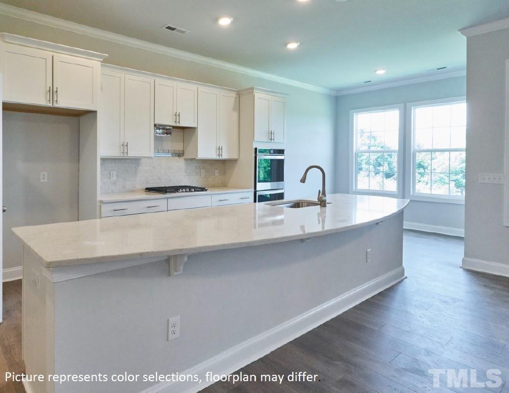5037 Chase Hill Way Raleigh, NC 27603 - Photo 41 of 41 a large kitchen with kitchen island a sink stainless steel appliances and cabinets