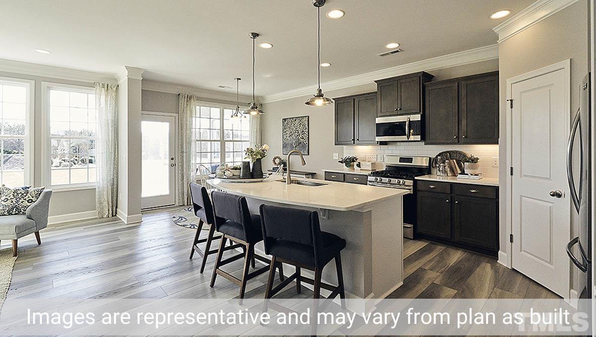 5037 Chase Hill Way Raleigh, NC 27603 - Photo 8 of 41 a kitchen with stainless steel appliances granite countertop a stove a refrigerator a sink a dining table and chairs with wooden floor