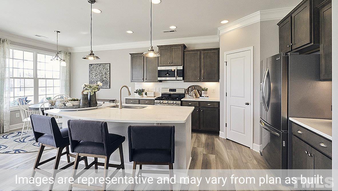 5037 Chase Hill Way Raleigh, NC 27603 - Photo 9 of 41 a kitchen with stainless steel appliances kitchen island granite countertop a refrigerator a sink dishwasher a stove and a dining table with wooden floor