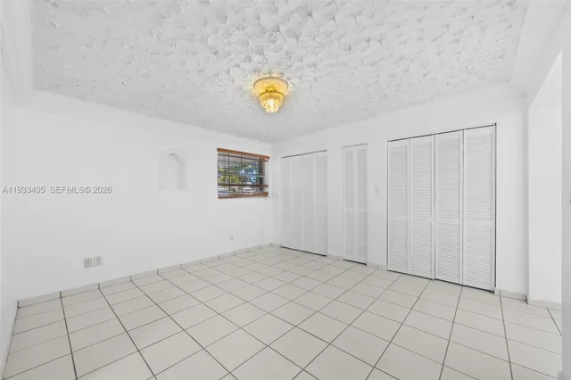 a large white room with kitchen view and wooden floor