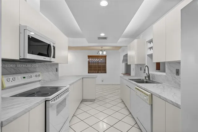 a kitchen that has a sink and a stove in it