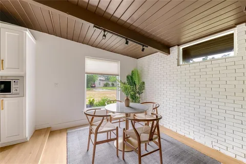 a patio with table and chairs and potted plants