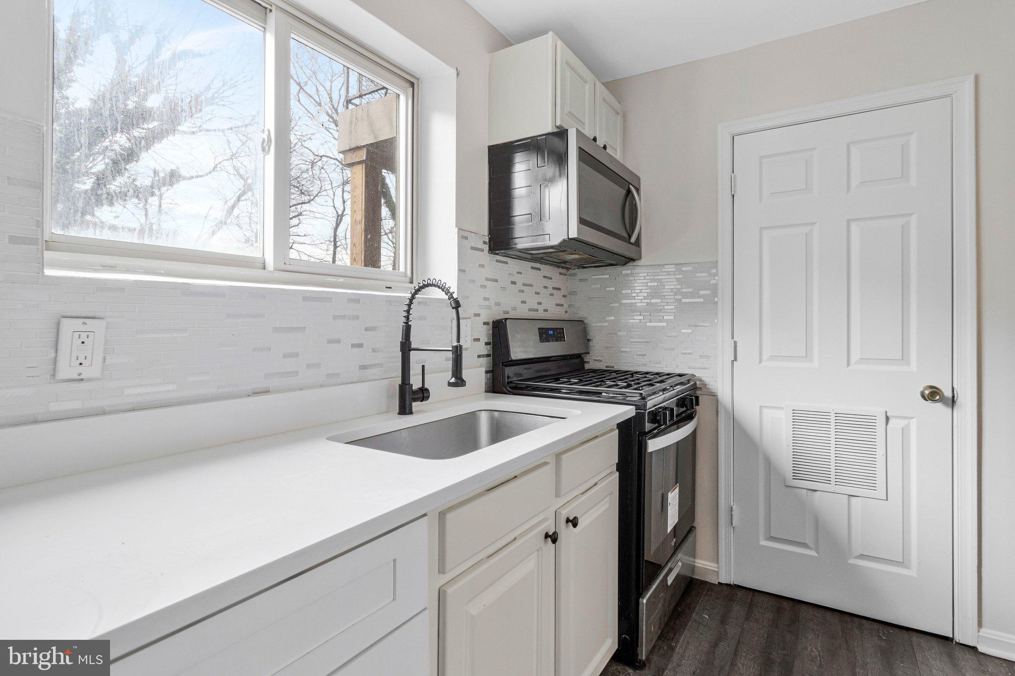 2608 Wade Road Southeast, Unit 202 Washington, DC 20020 - Photo 11 of 25 a kitchen with stainless steel appliances granite countertop a sink and a stove next to a window