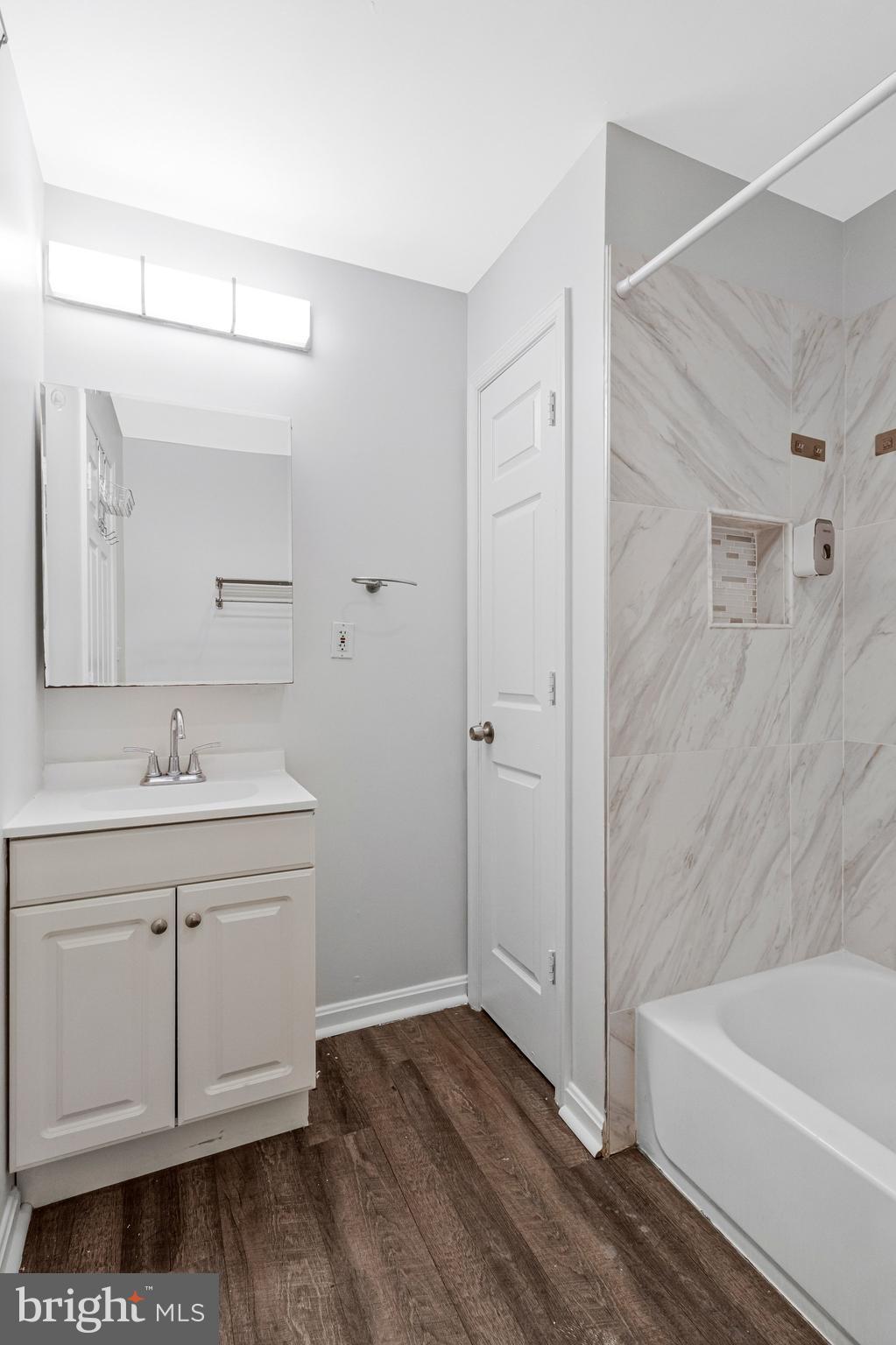 2608 Wade Road Southeast, Unit 202 Washington, DC 20020 - Photo 13 of 25 a bathroom with a tub sink and mirror