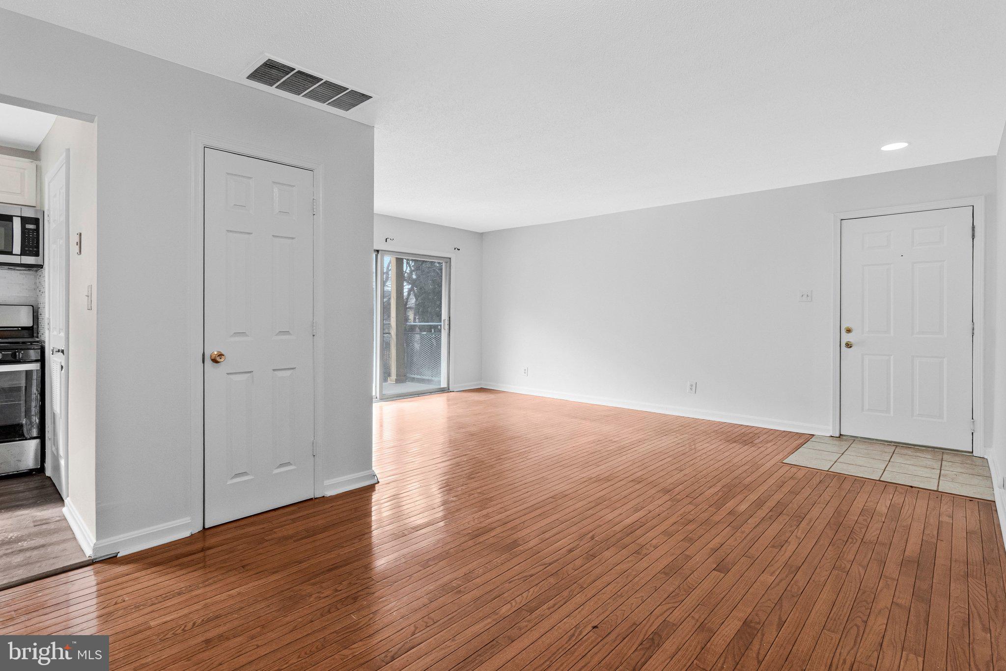 2608 Wade Road Southeast, Unit 202 Washington, DC 20020 - Photo 6 of 25 an empty room with wooden floor & windows