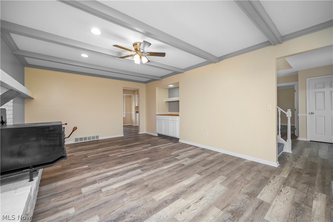 34725 Capel Road Columbia Station, OH 44028 - Photo 15 of 47 Spacious living area featuring wood-finish flooring, a beamed ceiling with recessed lighting and a ceiling fan, and a built-in wet bar with white cabinetry and a wood countertop
