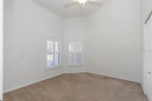 a bathroom with a granite countertop toilet a sink a mirror and a window