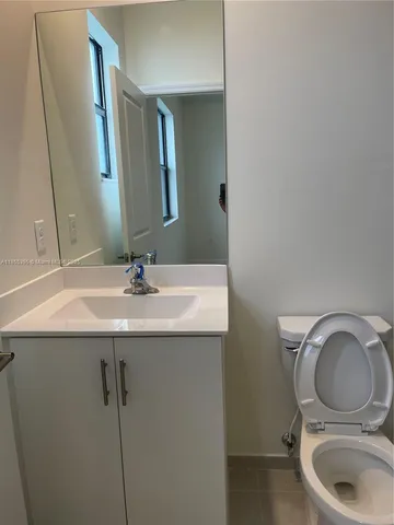 a bathroom with a sink a toilet and a mirror