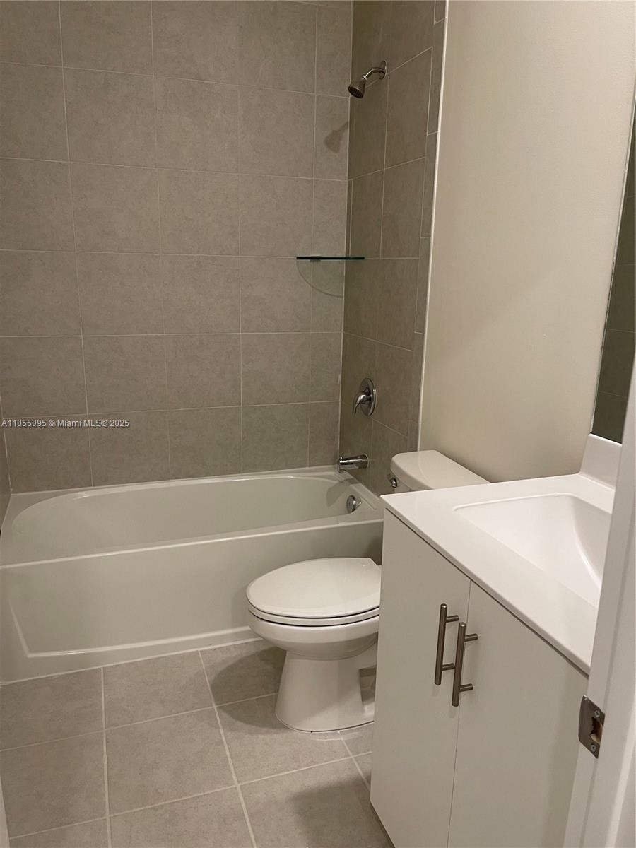 3244 West 114th Terrace, Unit 3244 Hialeah, FL 33018 - Photo 15 of 16 a bathroom with a sink a toilet and shower
