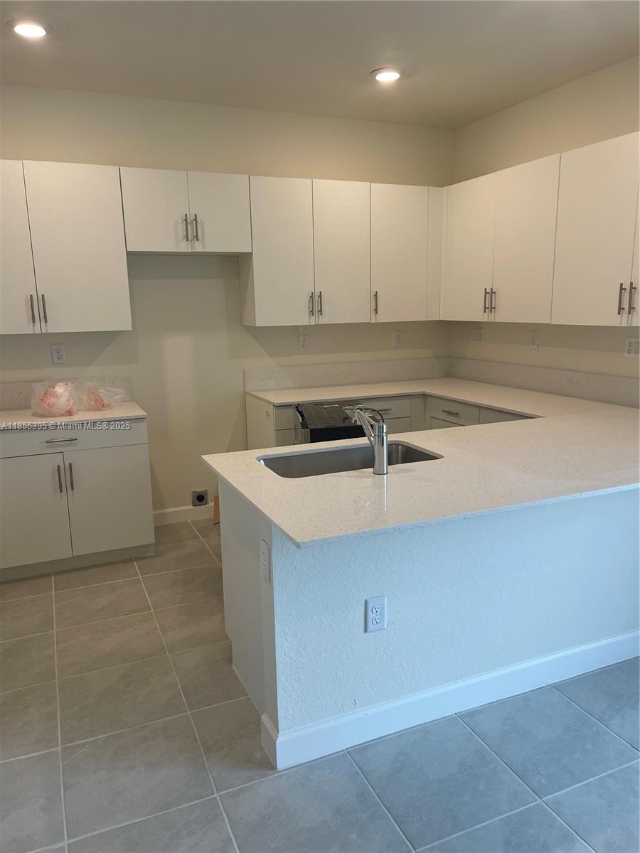 3244 West 114th Terrace, Unit 3244 Hialeah, FL 33018 - Photo 3 of 16 a kitchen with a sink and cabinets