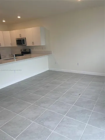 a view of kitchen with microwave and cabinets