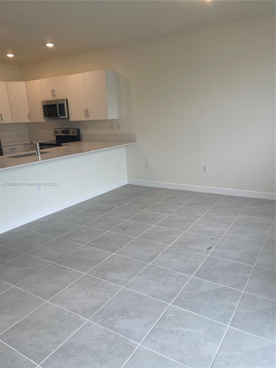 3244 West 114th Terrace, Unit 3244 Hialeah, FL 33018 - Photo 4 of 16 a view of kitchen with microwave and cabinets