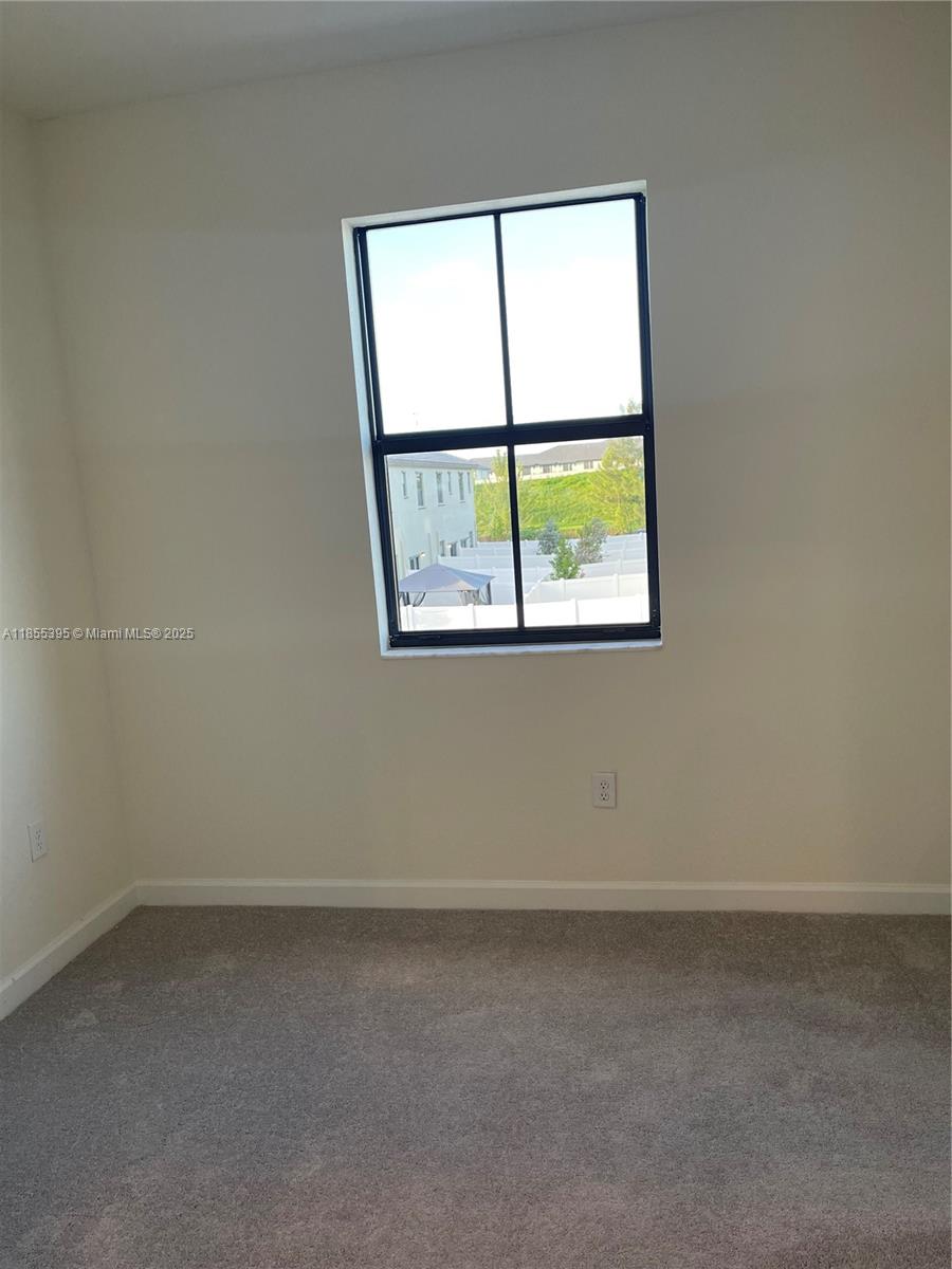 3244 West 114th Terrace, Unit 3244 Hialeah, FL 33018 - Photo 6 of 16 an empty room with a window