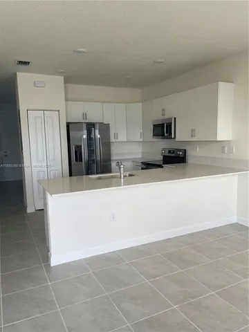 a kitchen with stainless steel appliances a refrigerator sink and microwave