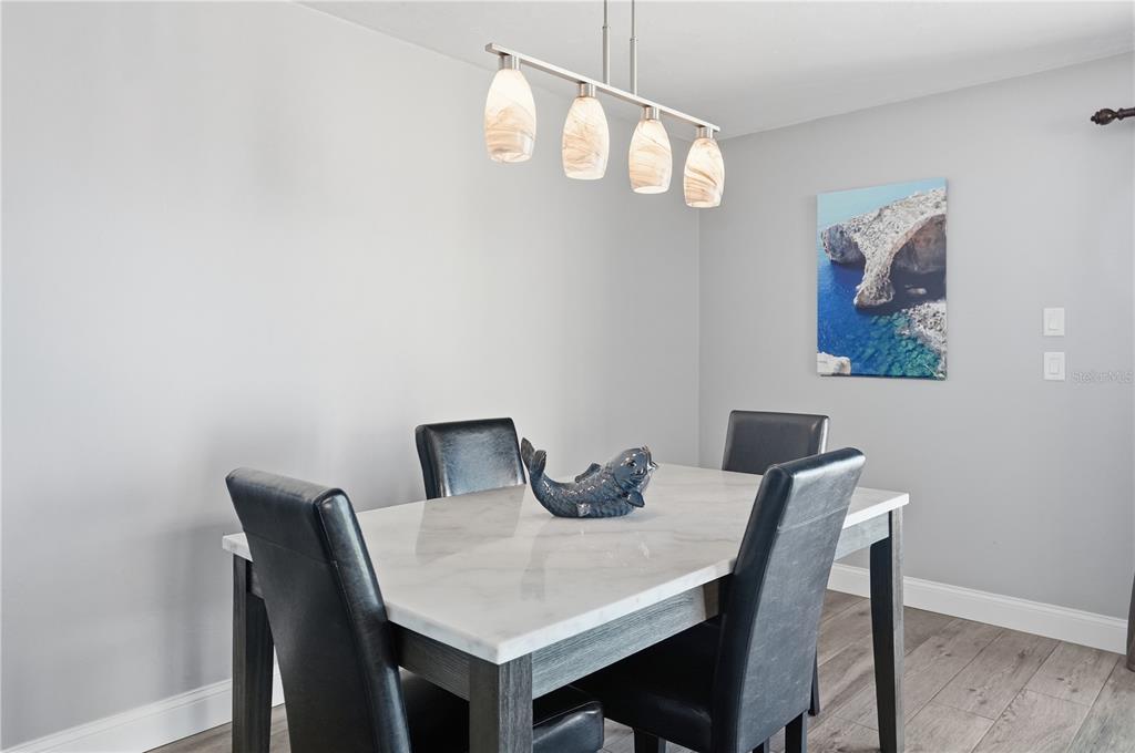 16330 Gulf Boulevard, Unit 306 Redington Beach, FL 33708 - Photo 17 of 39 a view of a dining room with furniture and wooden floor