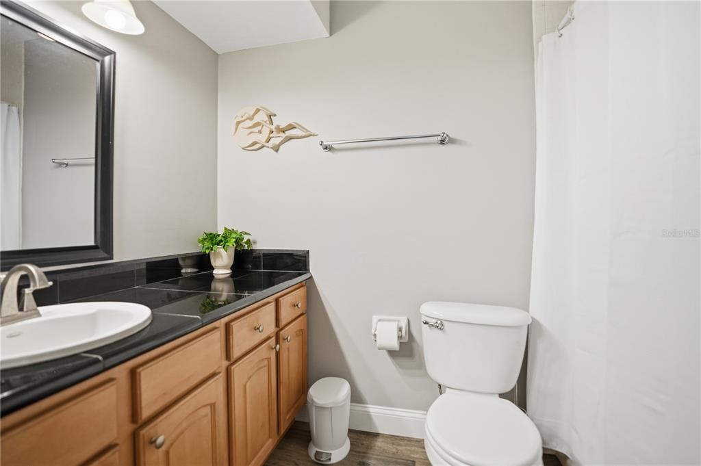 16330 Gulf Boulevard, Unit 306 Redington Beach, FL 33708 - Photo 26 of 39 a bathroom with a granite countertop toilet sink and mirror