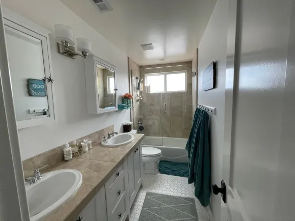 a bathroom with a granite countertop sink toilet and shower