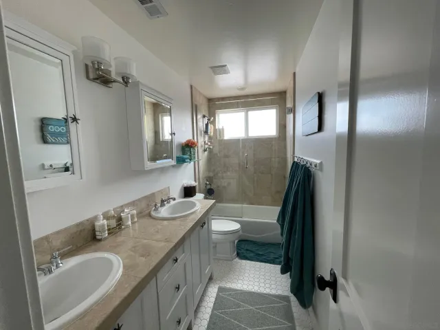 a bathroom with a granite countertop sink toilet and shower