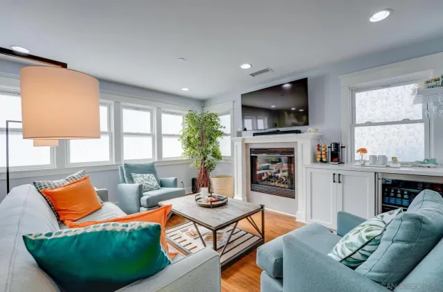 a living room with furniture a flat screen tv and a fireplace