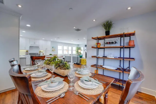 a dining room with furniture a chandelier and kitchen view