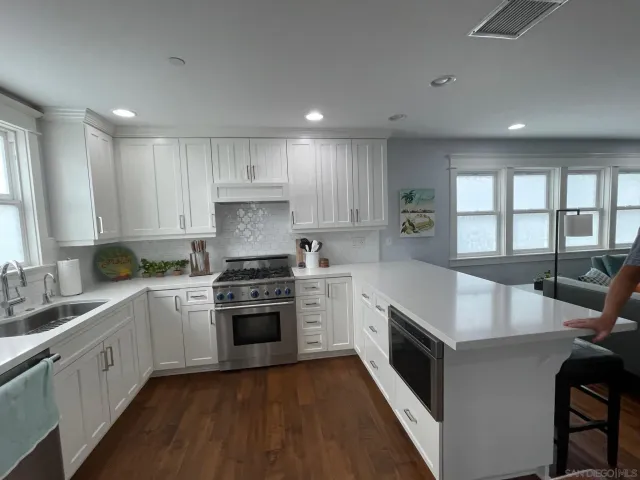 a kitchen with a stove sink and cabinets