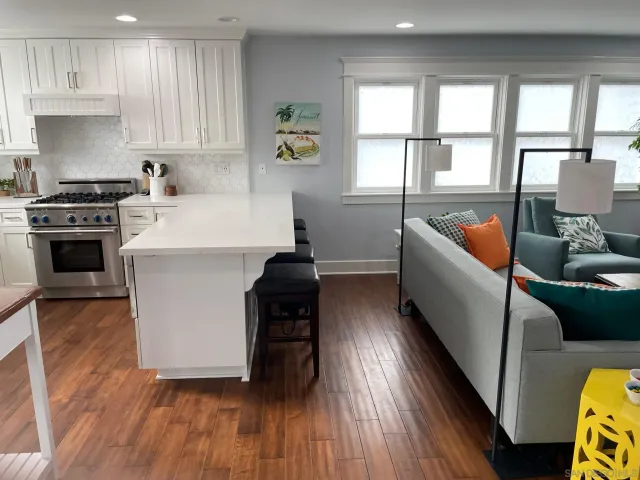 a kitchen with stainless steel appliances a stove a sink a refrigerator wooden floor and cabinets