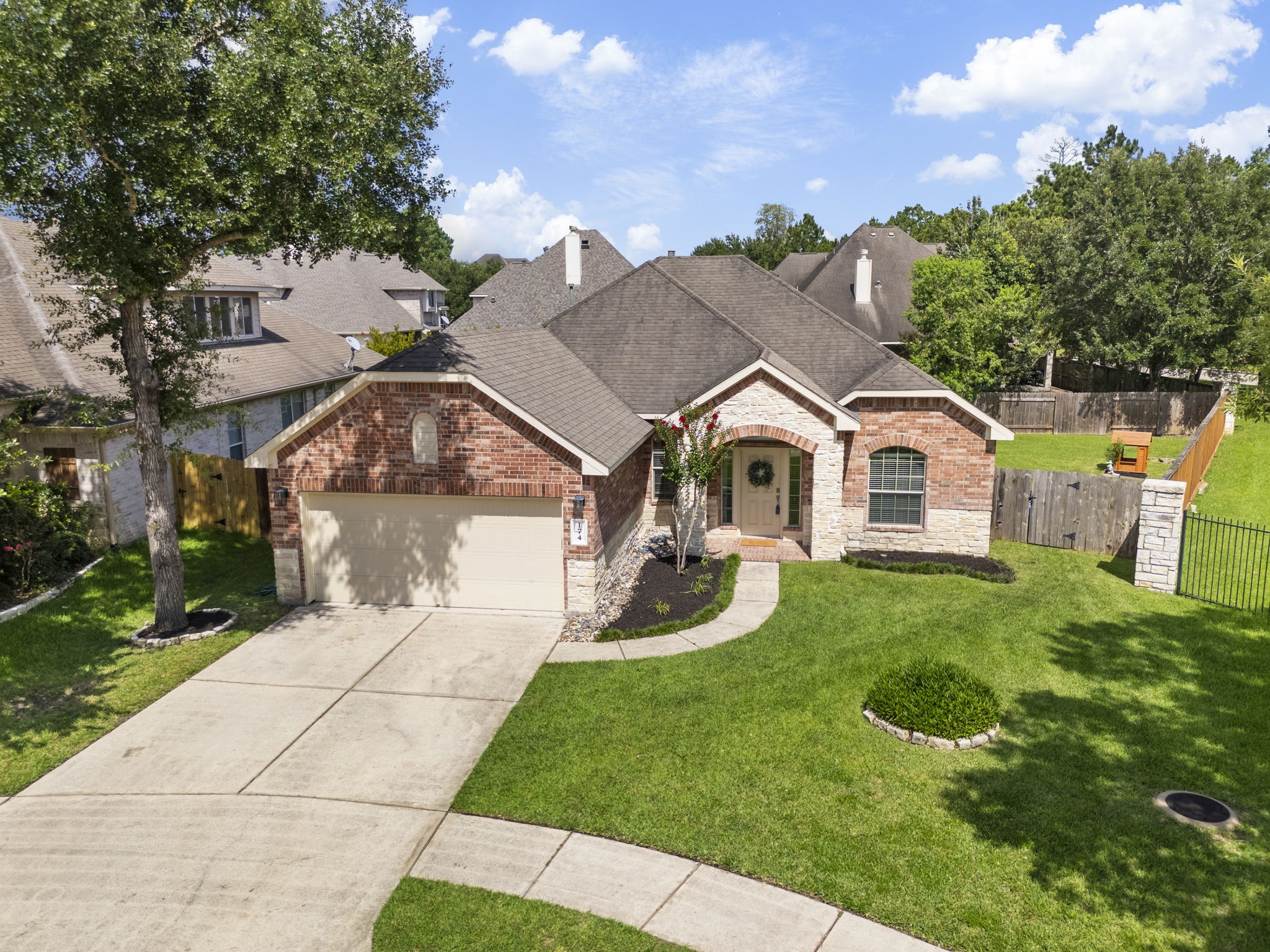 174 Maple Grove Drive Conroe, TX 77384 - Photo 2 of 26 Spacious green space to the right of the home provides a welcome buffer, adding privacy and a sense of openness between neighbors.
