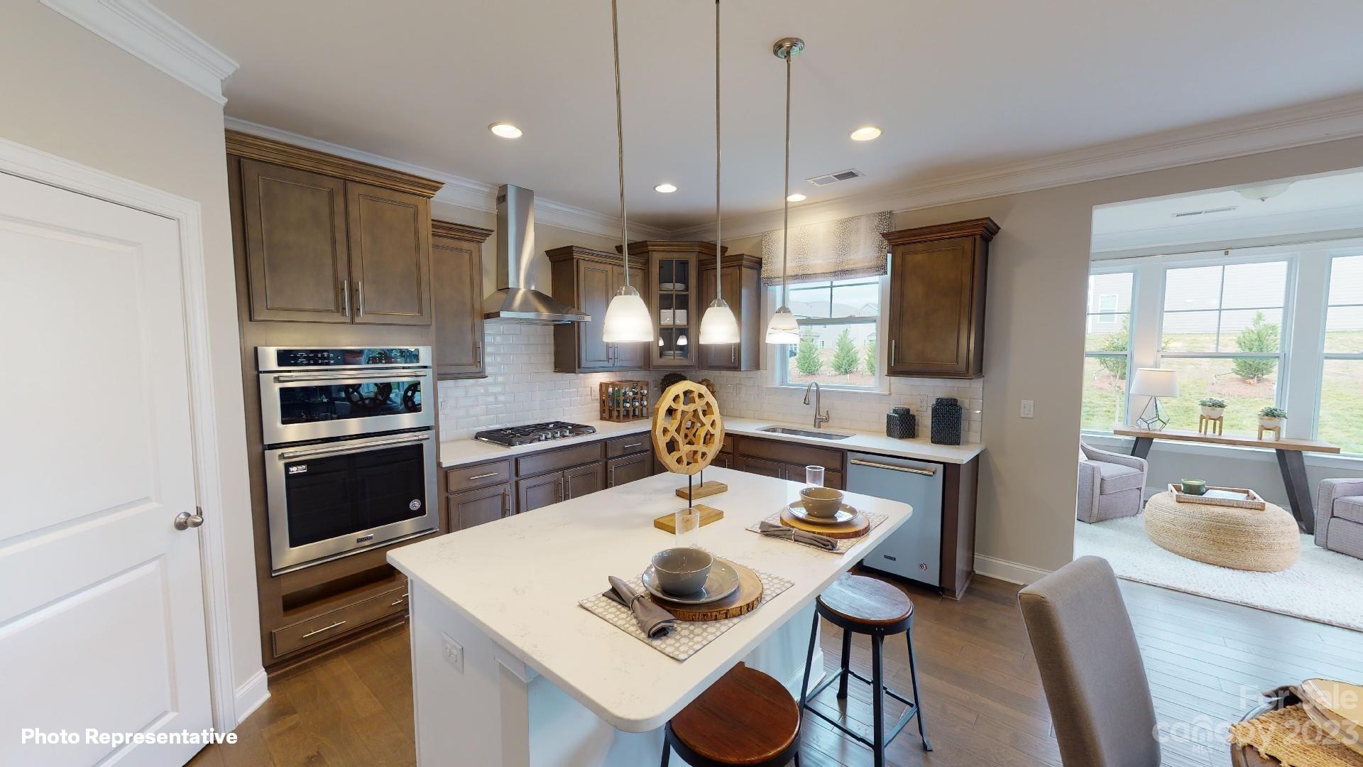 384 Streamwood Road Troutman, NC 28166 - Photo 4 of 36 a kitchen with kitchen island stainless steel appliances a sink and a refrigerator