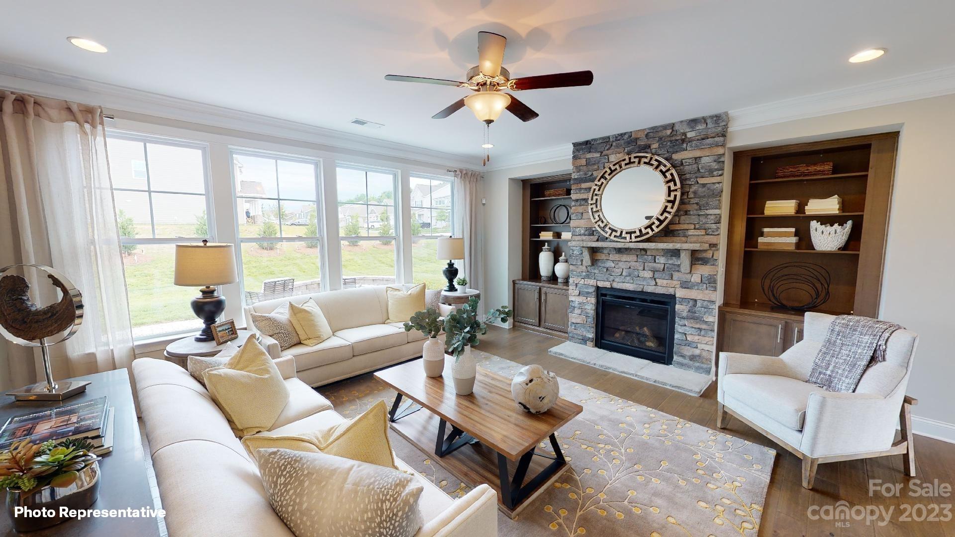 384 Streamwood Road Troutman, NC 28166 - Photo 9 of 36 a living room with furniture a fireplace and a large window