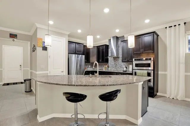 a large kitchen with a counter space a sink stainless steel appliances and cabinets