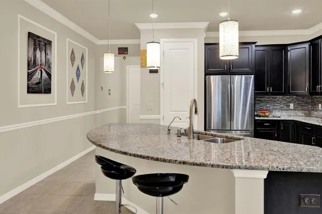 a kitchen with stainless steel appliances granite countertop a sink and a refrigerator