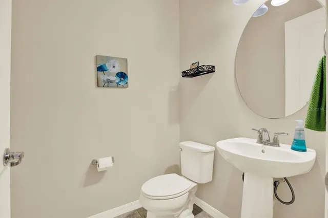 a bathroom with a toilet a sink and mirror