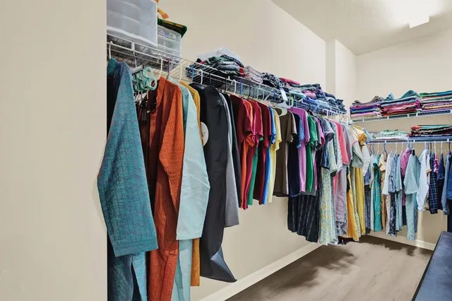 a view of walk in closet with clothes