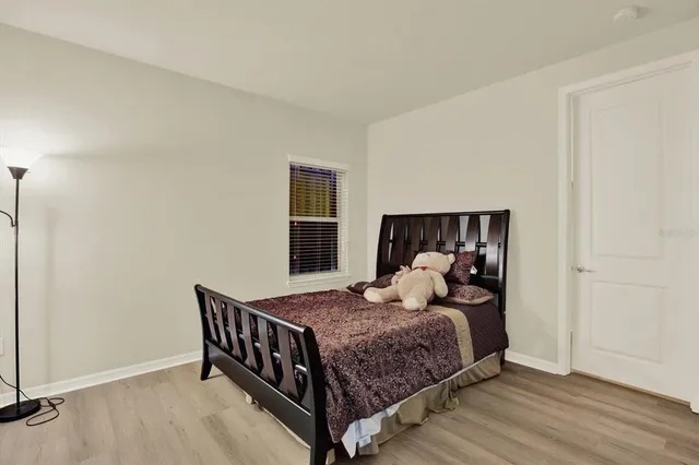 a bedroom with a bed and wooden floor