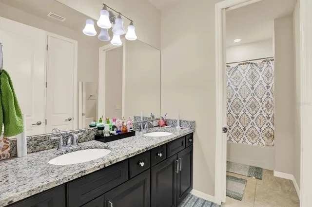a bathroom with double vanity sinks a vanity and a mirror