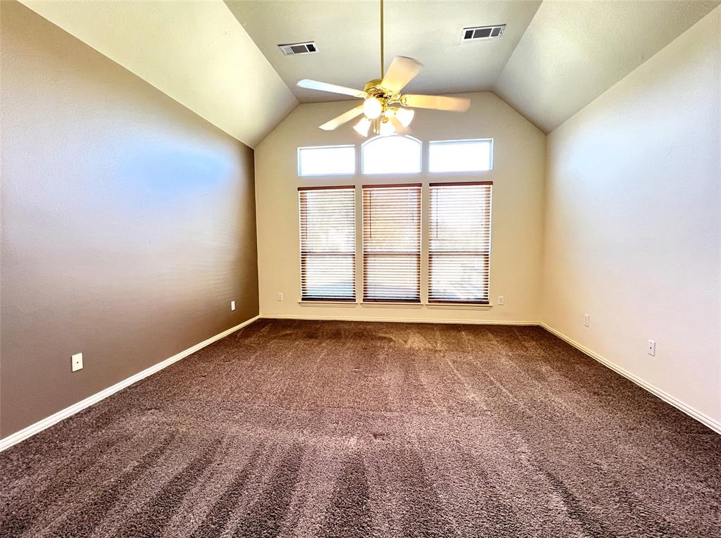7517 Rodeo Drive Denton, TX 76208 - Photo 13 of 30 an empty room with a chandelier fan and windows