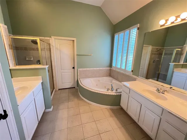 a bathroom with a tub sink and mirror