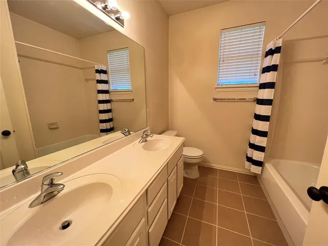 a bathroom with a double vanity sink toilet and shower