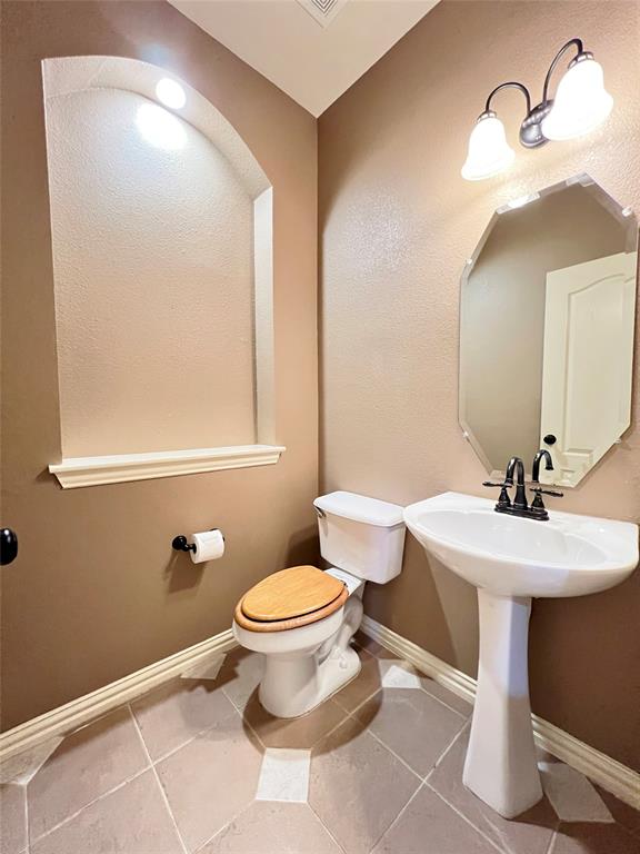 7517 Rodeo Drive Denton, TX 76208 - Photo 24 of 30 a bathroom with a toilet sink and mirror