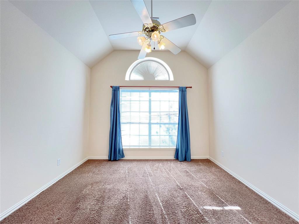 7517 Rodeo Drive Denton, TX 76208 - Photo 28 of 30 an empty room with a chandelier fan and windows