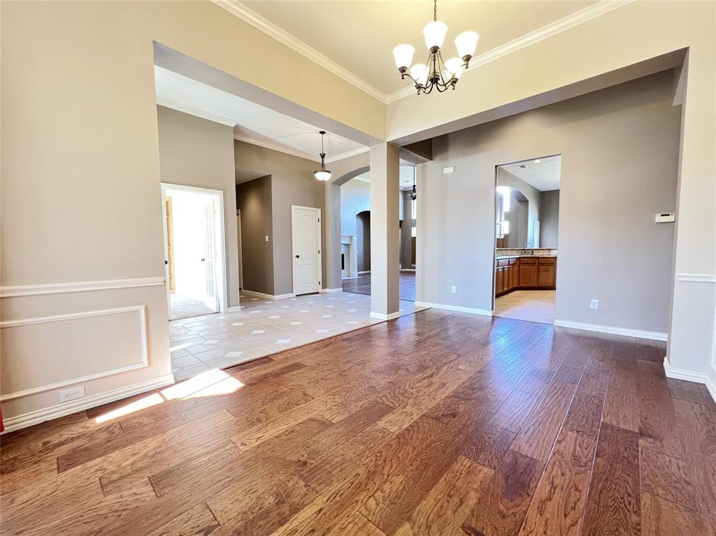 7517 Rodeo Drive Denton, TX 76208 - Photo 4 of 30 a view of a hallway with wooden floor and a chandelier