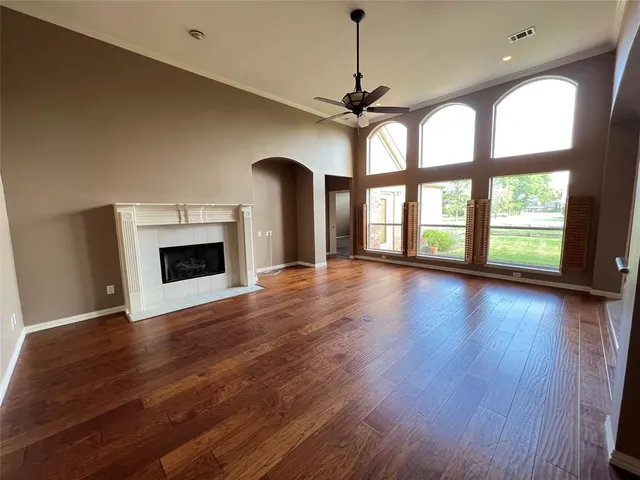 a view of an empty room with glass door and wooden floor
