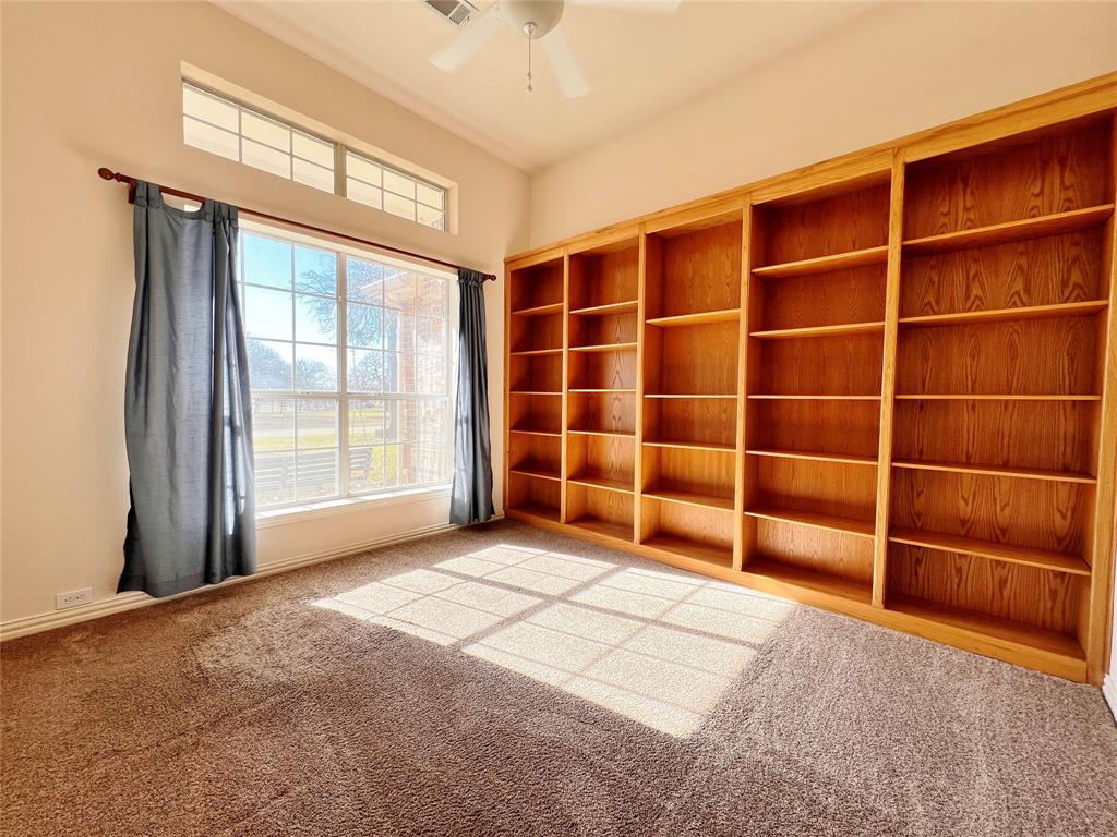 7517 Rodeo Drive Denton, TX 76208 - Photo 5 of 30 a view of an empty room with a empty shelves and a window