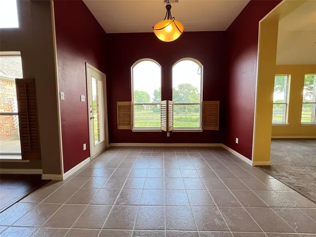a view of an empty room with a fireplace and a window