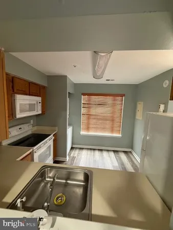 a view of kitchen island with sink stainless steel appliances and cabinets